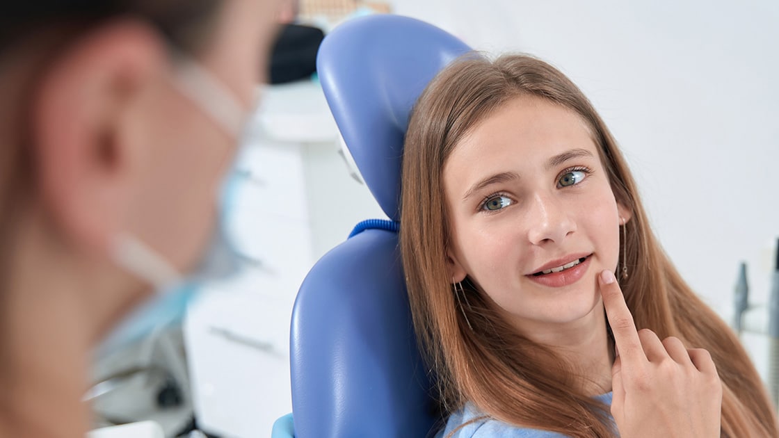 Girl pointing to teeth